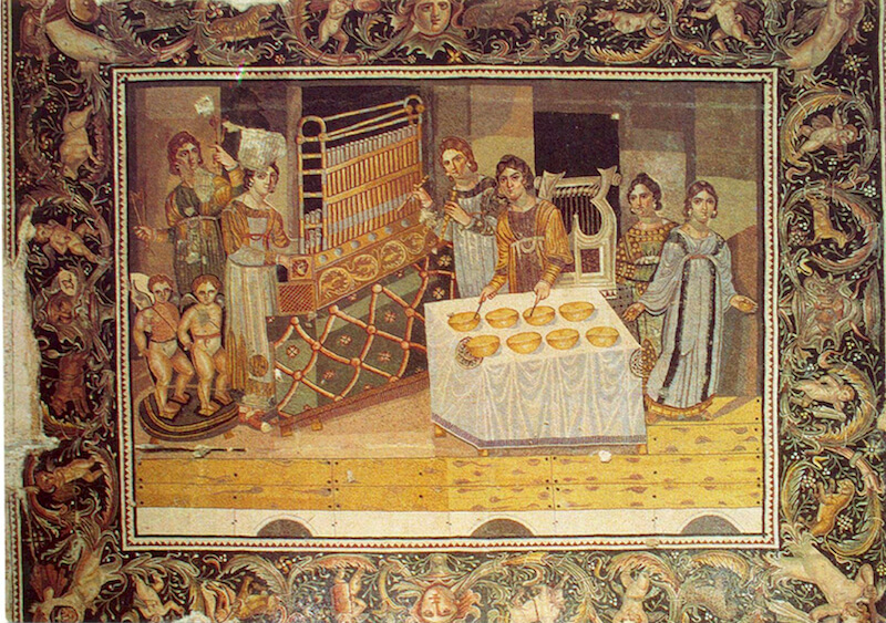  Женщина (слева), играющая на портативном органе. Мозаика из византийской виллы в деревне Марьямин (близ г. Хама), конца IV в. н. э. Археологический музей г. Хама
